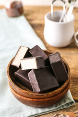 Bowl with tasty bird's milk candies on wooden table, closeup