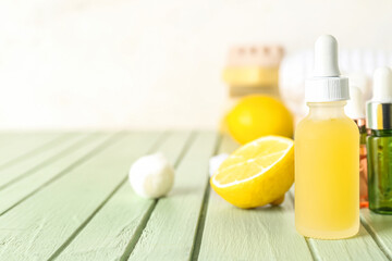 Bottle of citrus serum on color wooden table