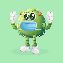 Cute green monster wearing medical mask, protect from covid-19