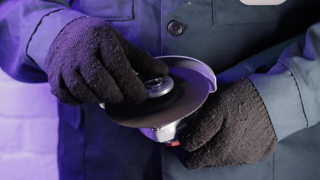 Installing a reinforced cutting wheel on an angle grinder for cutting metal.
