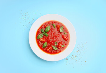 Plate of tasty tomato soup on color background