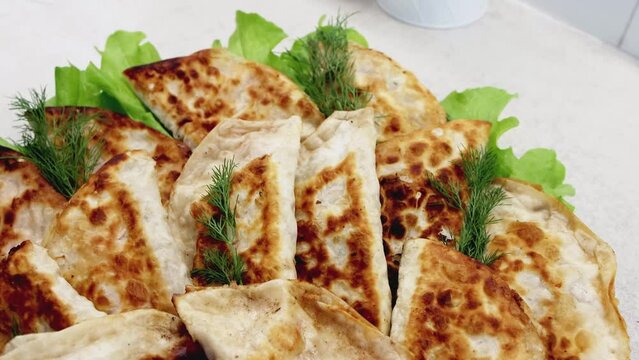 Dish with delicious fried chebureks made from dough and minced meat. Homemade fast food. Close-up