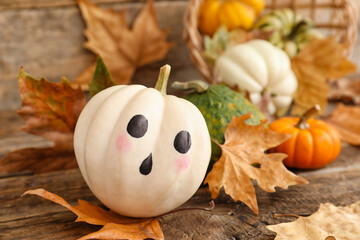 Halloween pumpkins and autumn leaves on wooden table