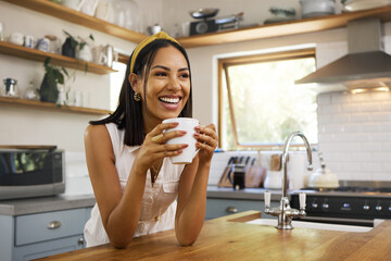 Happy woman, coffee or tea in home kitchen and relax with a smile in the morning at house. Calm...