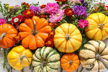 Composition with Halloween pumpkins and autumn flowers on table, closeup