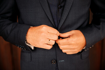 Groom buttons his suit. put on a wedding suit