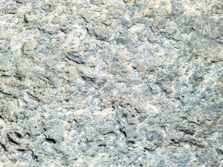 Grey beige stone wall background texture. Rocky formation with holes. Greek island Cyclades Greece.