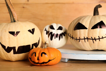 Different Halloween pumpkins on wooden background, closeup