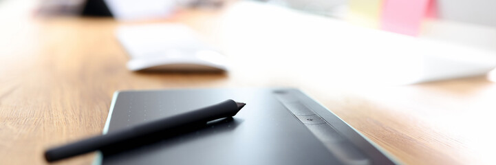 Graphic tablet and stylus on designer desktop closeup
