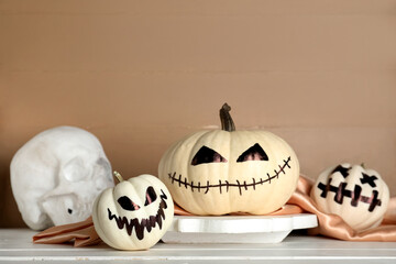 Halloween pumpkins with drawn faces on light wooden table