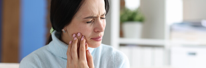 Young woman with severe toothache at home