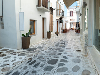 Greece Tinos island, Chora town. Cyclades architecture, outdoors cafe, cobblestone alley.