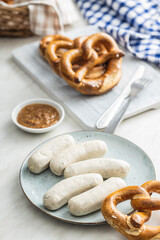 Traditional Bavarian white sausages on plate and pretzes.