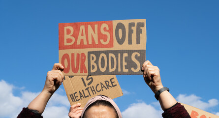 Protesters holding signs with slogans Bans Off Our Bodies and Abortion Is Healthcare. People with...