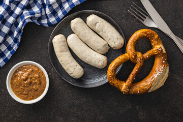 Traditional Bavarian white sausages on plate and pretzes.