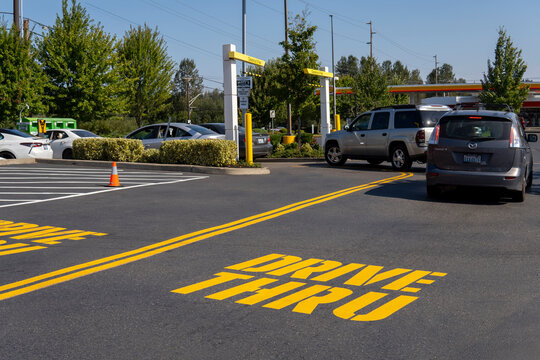 McDonald's Restaurant With Cars Line At Drive Thru At Sunny Day. Fast Food Place. Everett, WA, USA - October 2022