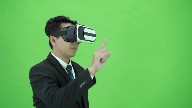 Businessman on Chroma Green Screen using gesture control while using Virtual Reality or VR platform.