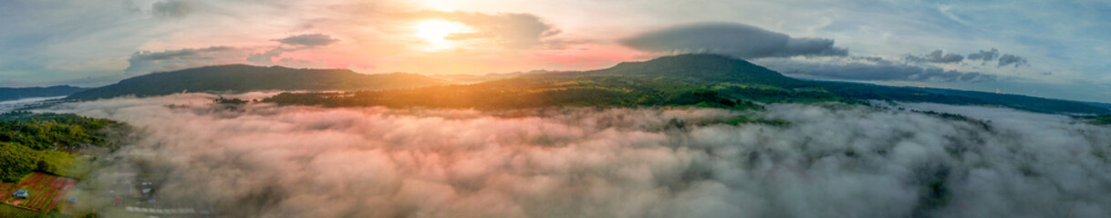 Mountains in fog at beautiful autumn in Phetchabun Thailand. Fog mountain valley, low clouds, forest, colorful sky with.  pine trees in spruce foggy forest with bright sunrise