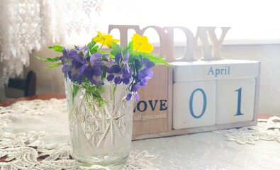Spring flowers are purple and yellow. Flowers in a vase. Calendar. April first. Violets. - 537720195
