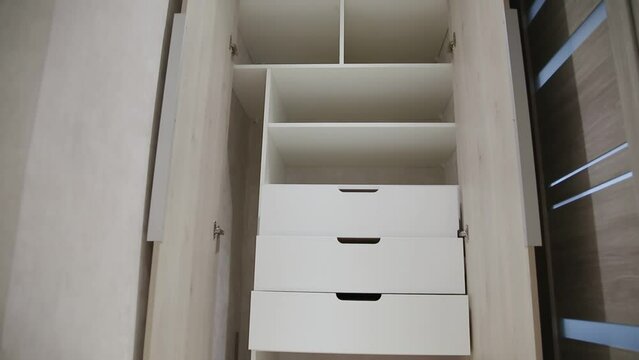 Modern closet in the hallway with hinged doors and pull-out shelves. Production of furniture under the order.