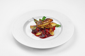 Foie gras with berry sauce on a white plate on a white plate. Close-up. Selective focus