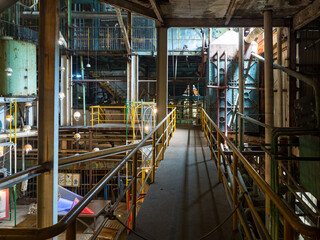 the interior of an abandoned factory with pipes and rusty metal structures