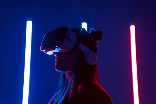 Lady in VR goggles against neon lights
