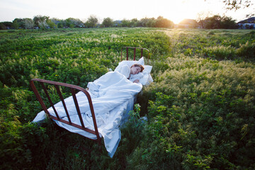 bed in a green field - 537726799