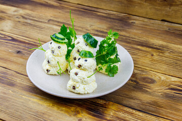 Christmas salad in the shape of snowmen and Christmas tree on a plate on wooden table