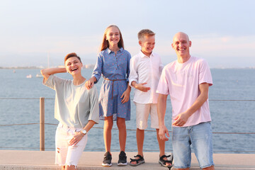 mom, dad, daughter and son happy family on sea marina background