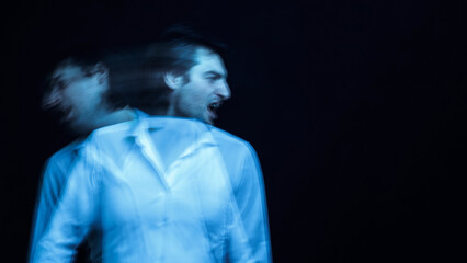 schizophrenic portrait of psychopathic man with mental disorders in white shirt on dark background