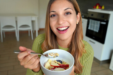 Cheerful woman having healthy breakfast at home