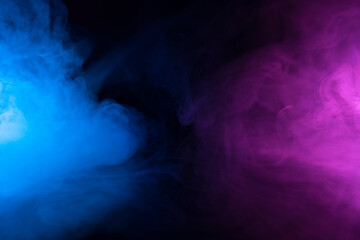 Clouds of smoke in blue and purple neon light swirling on black table background with reflection