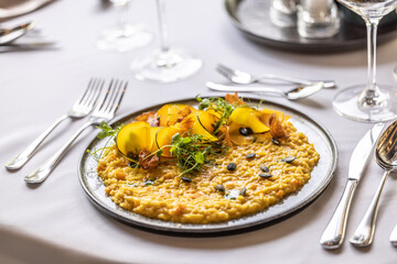 Creatively cooked pumpkin risotto served on a ceremonially prepared table in the hotel restaurant