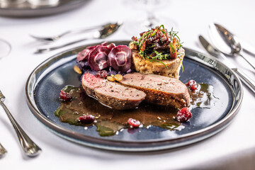 Creatively duck breast served on a ceremonially prepared table in the hotel restaurant