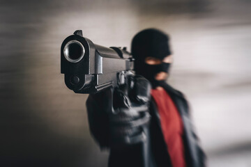 shooter in black mask attacks. concept of banditry theft crime. Armed terrorist, thief with pistol...