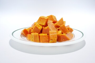Ripe papaya fruit in a plate on a white background