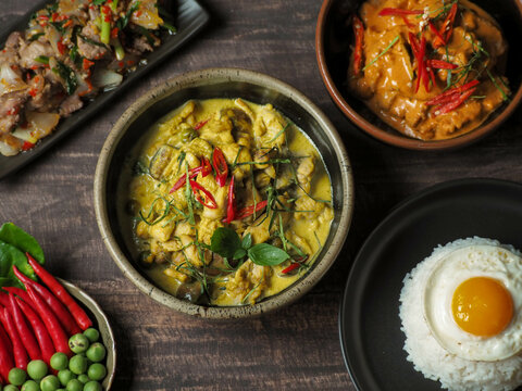 A full set of Thai food on a wood table