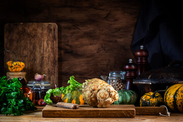 Autumn food cooking background with organic farm vegetables: celery root, pumpkin, herbs and spices...