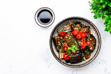 Grilled spicy eggplant with hot red chili peppers, soy sauce, garlic and sesame seeds in asian...