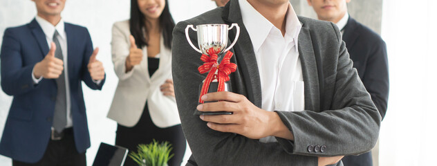 Businessman holding cup prize from company best employee reward