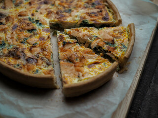 Home made salmon Quiche on a wood table with beautiful light for background