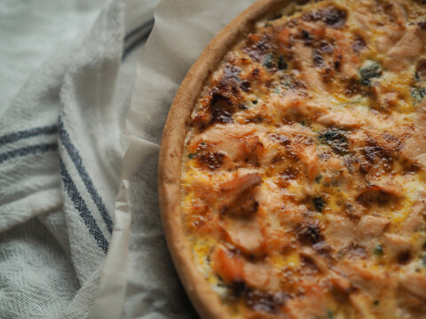 Home made salmon Quiche on a wood table with beautiful light for background