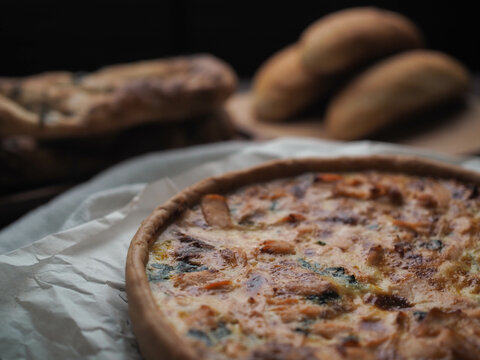 Home made salmon Quiche on a wood table with beautiful light for background