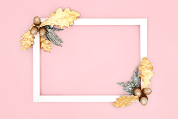 Winter Christmas New Year minimal background border frame on pink with gold oak leaves, acorns and...