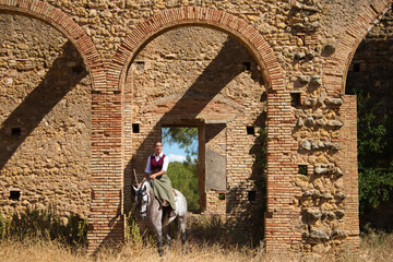 Young and beautiful Spanish woman on a Thoroughbred horse for competition. The woman has gone out...