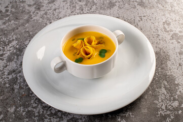 Fresh and healthy pumpkin cream soup with herbs. Vegan cuisine