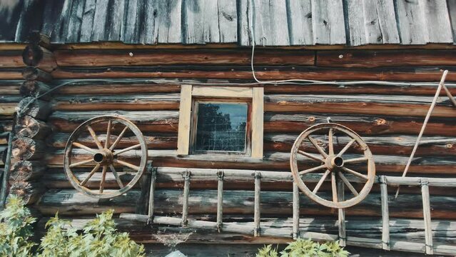 Old rural shed and wood wheels hanging on the wall. 