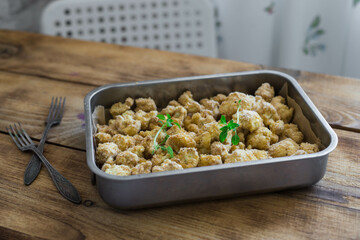 Breaded cauliflower on a wooden table, close-up, top view, selective focus, no people.