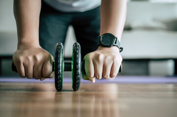 Young fat man workout with ABS hand-roller